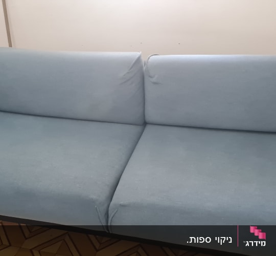 ספה כחולה בחדר עם כריות ודמויות קטנות